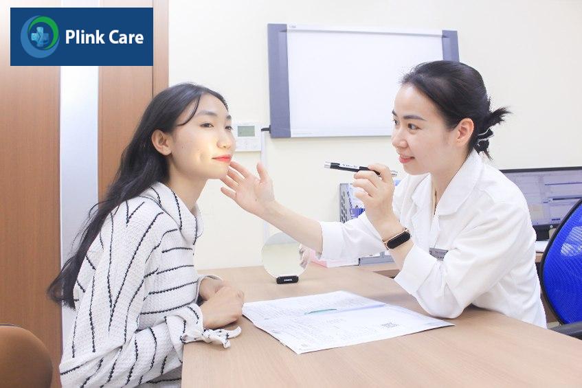 Bác sĩ chuyên khoa Da liễu - Thẩm mỹ Da dùng đèn soi để đánh giá tình trạng mụn đầu đen ở mũi.