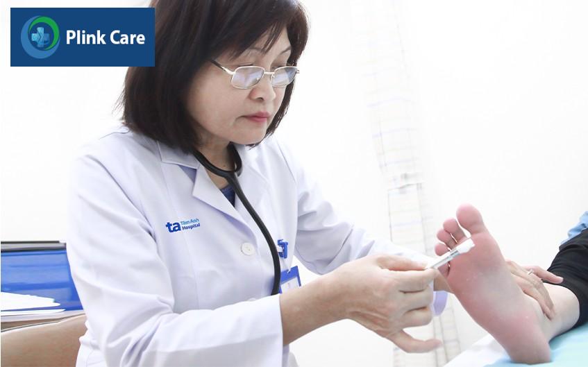 Bác sĩ Mai đang khám bàn chân cho người bệnh