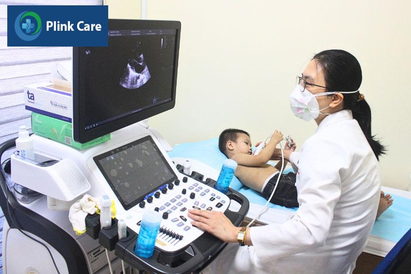 Bác sĩ thực hiện chẩn đoán bằng phương pháp siêu âm tim cho trẻ