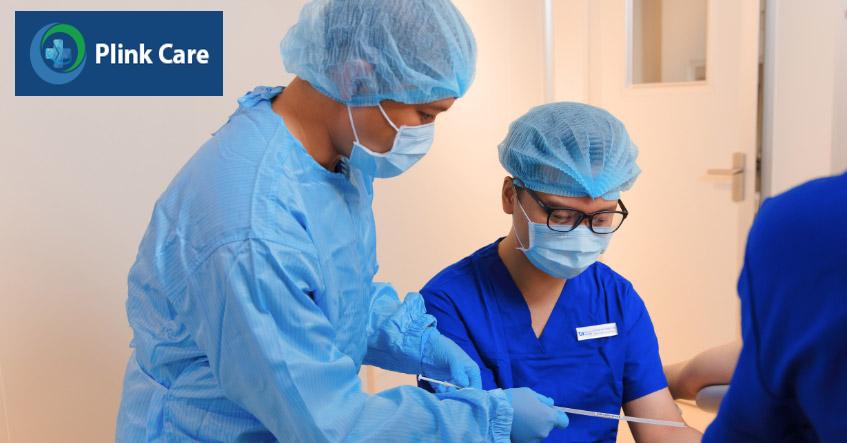 Bác sĩ và chuyên viên phôi học kiểm tra catheter chứa phôi trước khi chuyển