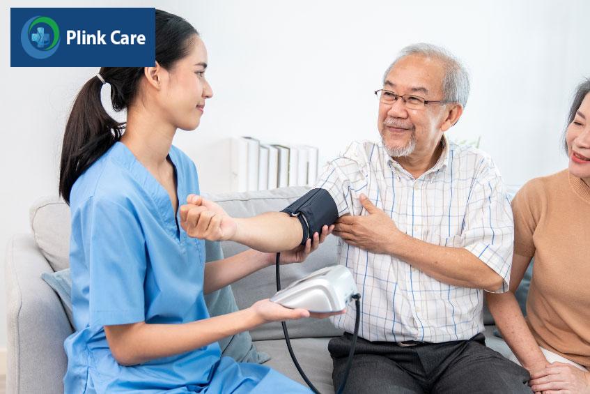 Kỹ thuật viên hỗ trợ đo huyết áp cho bệnh nhân